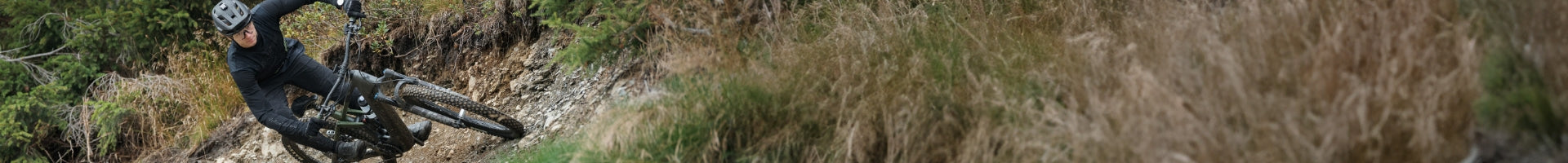 Mountainbiker auf einem Cube E-Bike fährt schnell durch eine Waldkurve, geeignet für Offroad-Abenteurer.