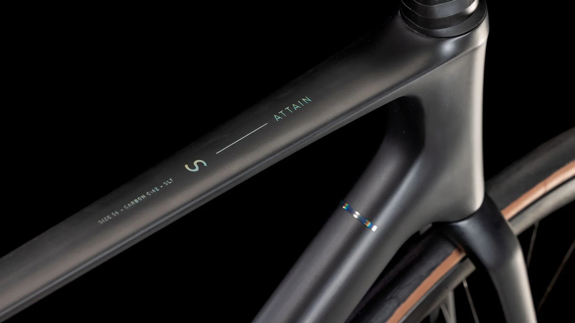 Nahaufnahme eines schwarzen Fahrradrahmens mit der Aufschrift "Attain", geeignet für Straßenrennsport.